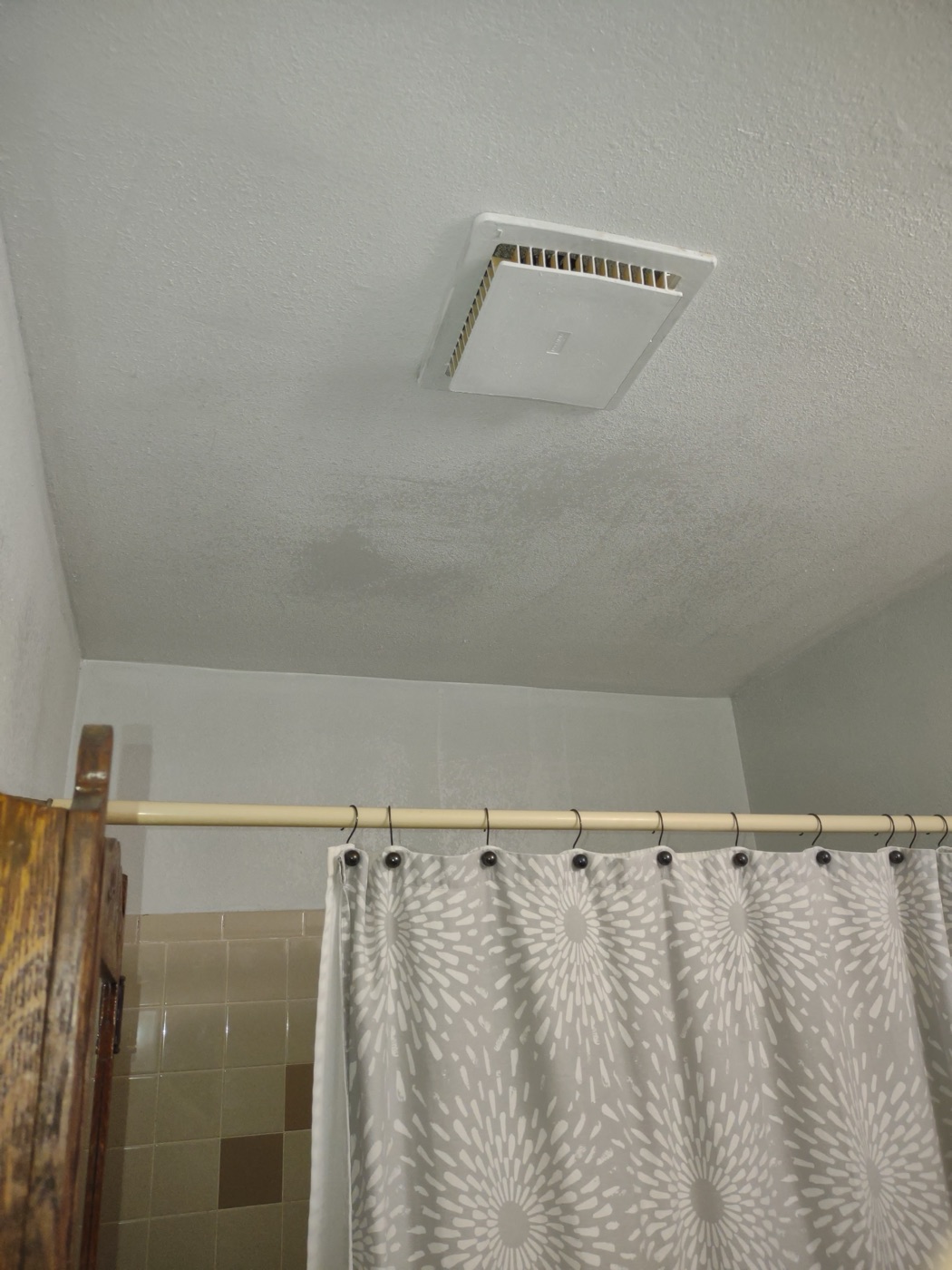 Finished bathroom ceiling — painted white with exhaust fan reinstalled