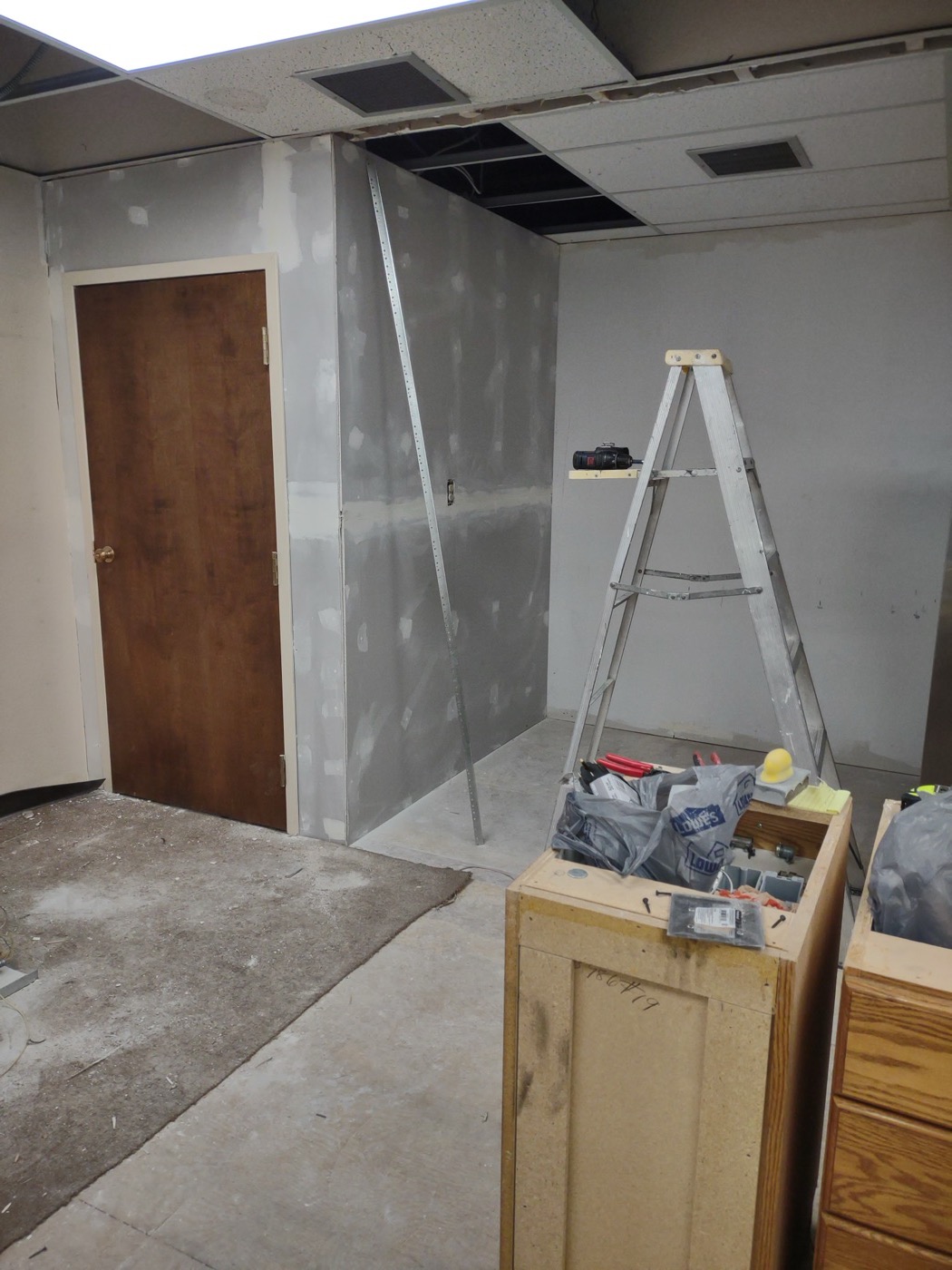 New walls framed and drywalled inside a commercial space, drop ceiling visible above